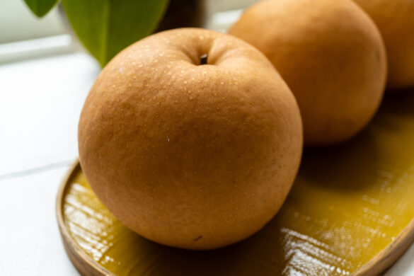 A closeup side shot of the Asian pear on a yellow tray.