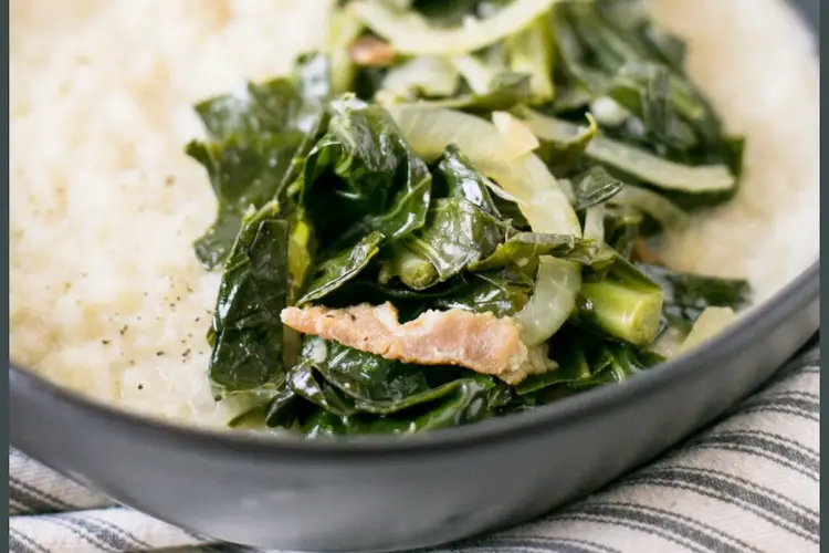 A close up shot of white grits with greens