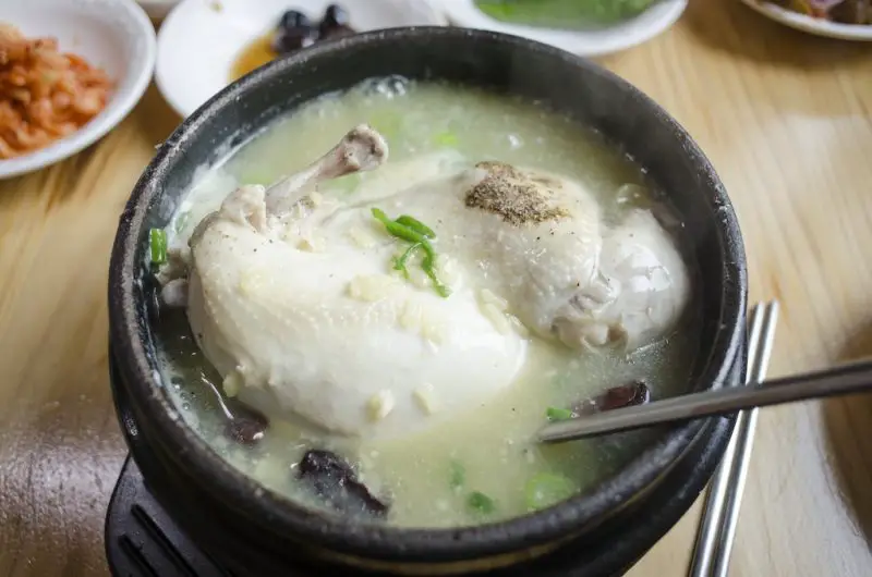 A bowl of Korean samyetang--a bowl with broth and chicken.