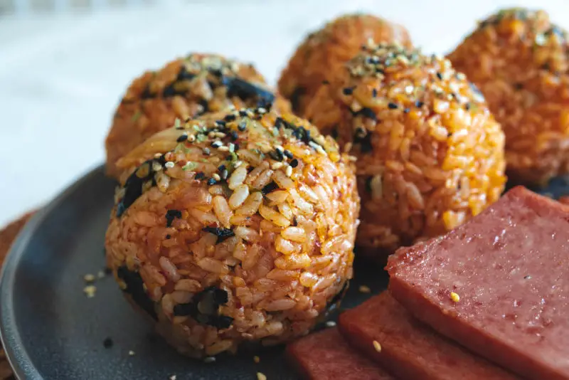 Kimchi rice balls sitting next to spam. 