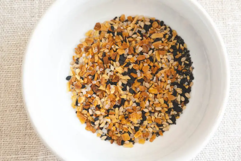 An overhead shot of a white bowl with everything bagel seasoning inside. 