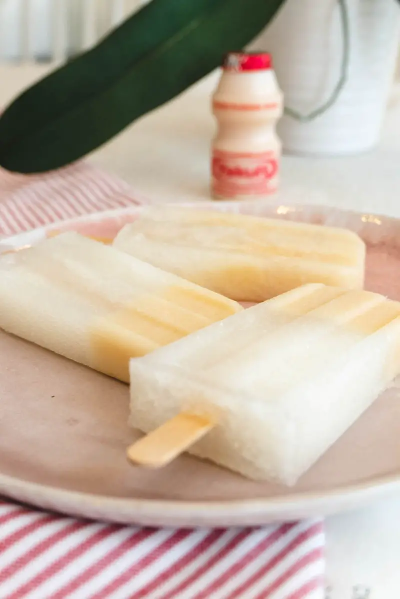 A side shot of Yakult soju popsicles on a pink plate. 