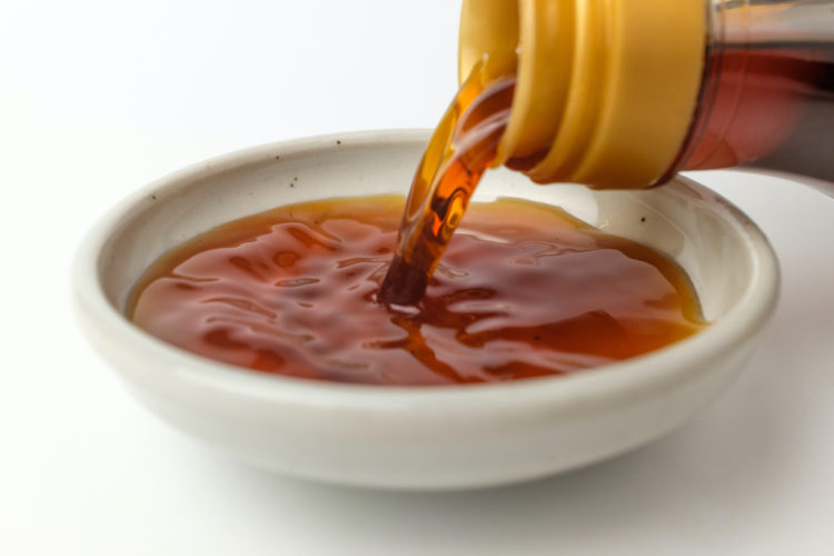 Korean fish sauce being poured into a bowl.
