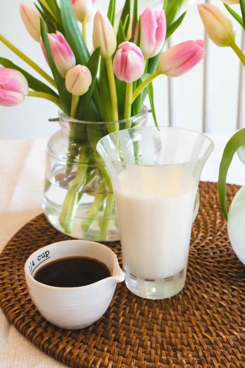 A small cup of espresso next to a glass of milk. 