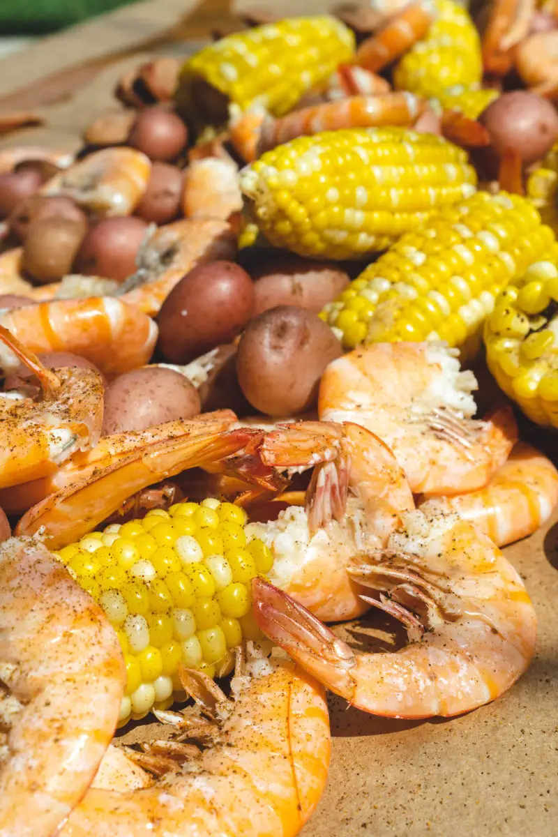 A table filled with shrimp, corn, sausage, and potatoes. 