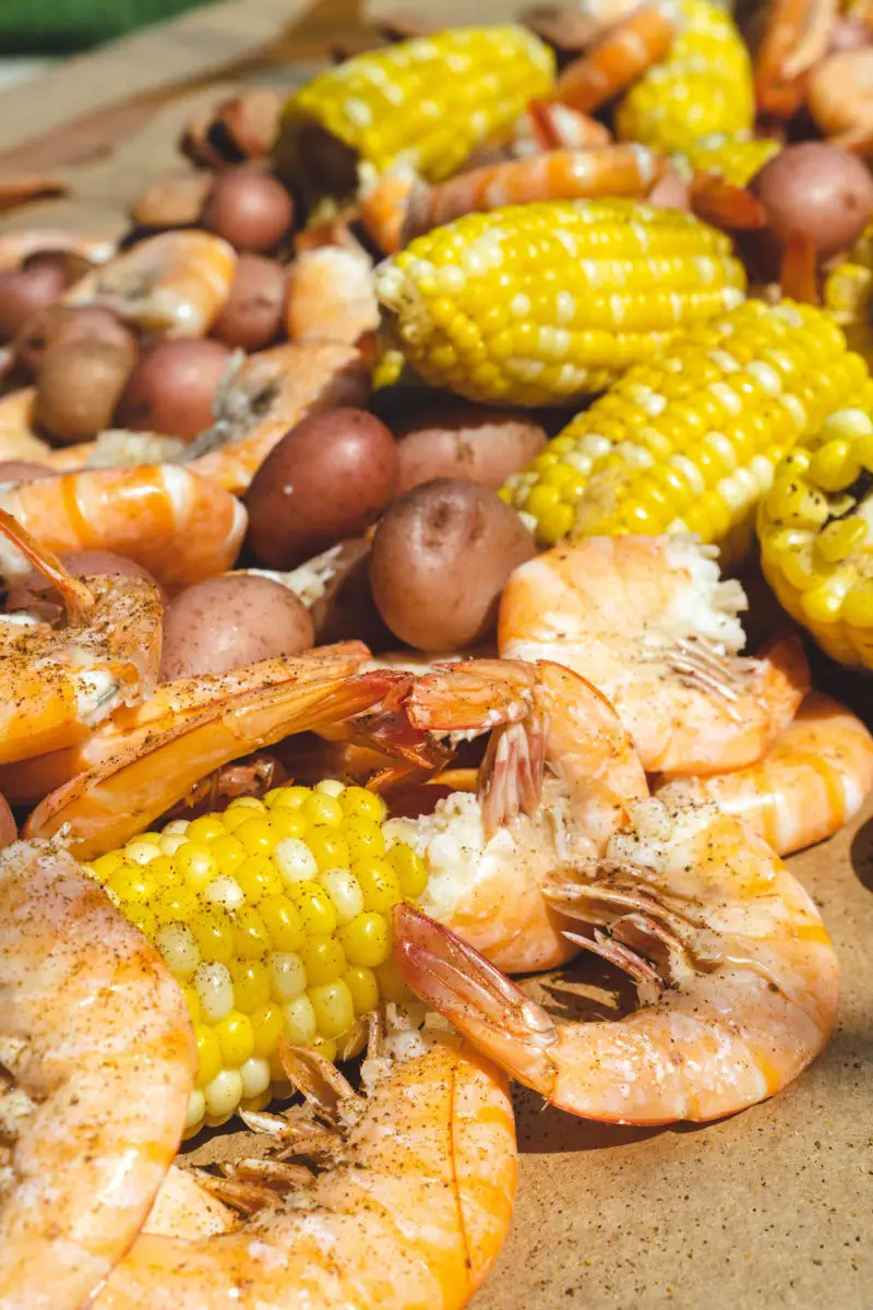 A table filled with shrimp, corn, sausage, and potatoes.