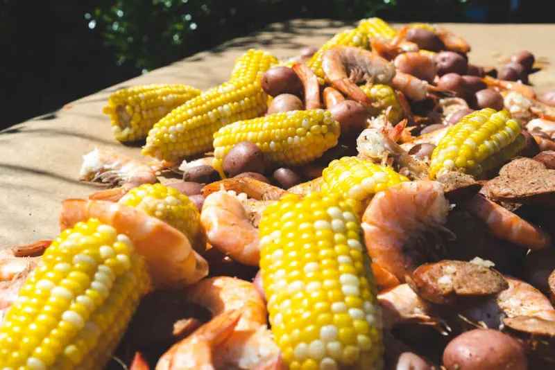 A Lowcountry shrimp boil table filled with shrimp, corn, sausage, and potatoes. 