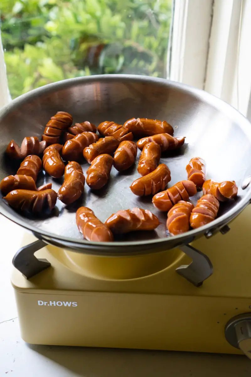 Korean sausages cooking on the stovetop.