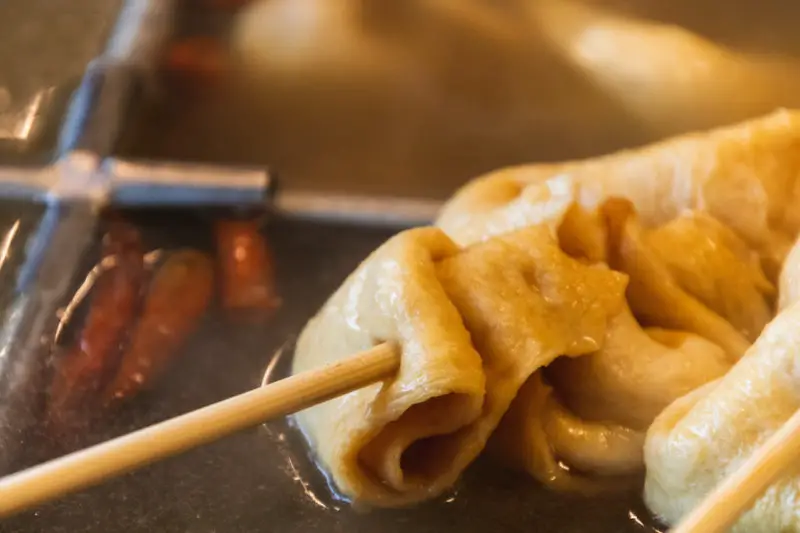 Korean fish cakes on a stick in broth.