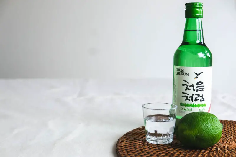 Soju next to a lime and soju glass.