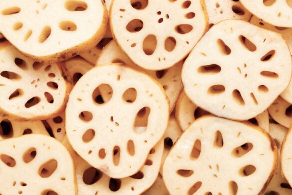 An overhead shot of sliced lotus root in a pile. You can see the natural holes created in the root when sliced.