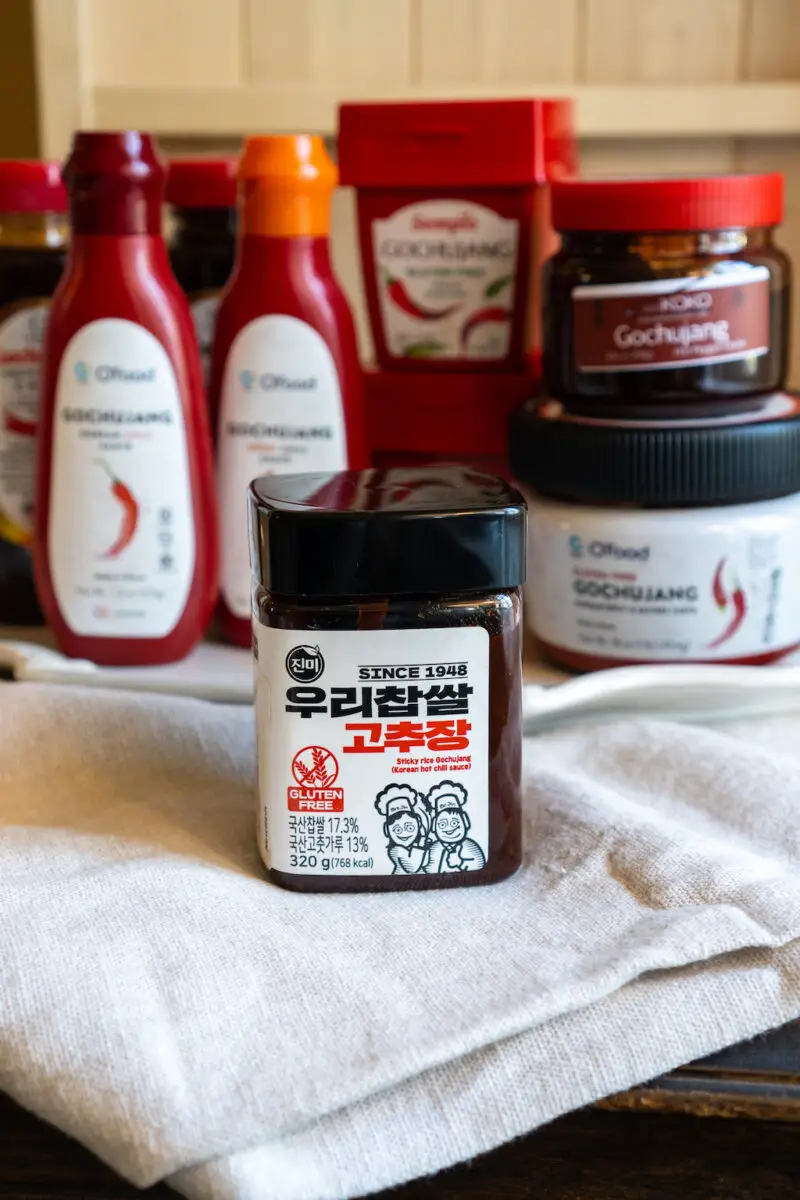 Jinmi gluten-free gochujang container sitting in the foreground. In the background sits other containers and brands. 