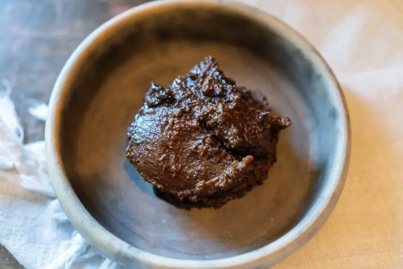 An overhead photo of Korean soybean paste (doenjang) sitting in a grey bowl. 