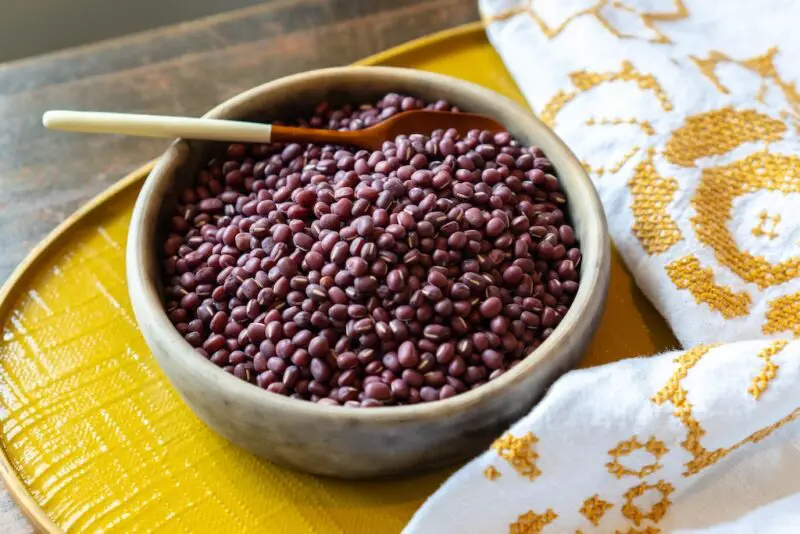 A photo of dried rKorean pat in a bowl. The bowl is sitting on a yellow tray next to a table cloth. 